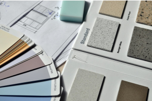 a table with blueprints and building material colour choices laying on it