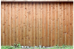 a treated timber fence with grass at the bottom