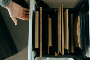 a man opening a drawer full of wood sheet material samples