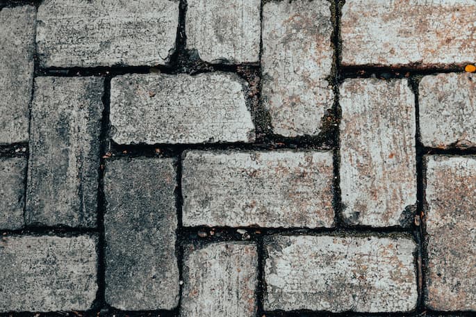A surface of grey patio paving slabs