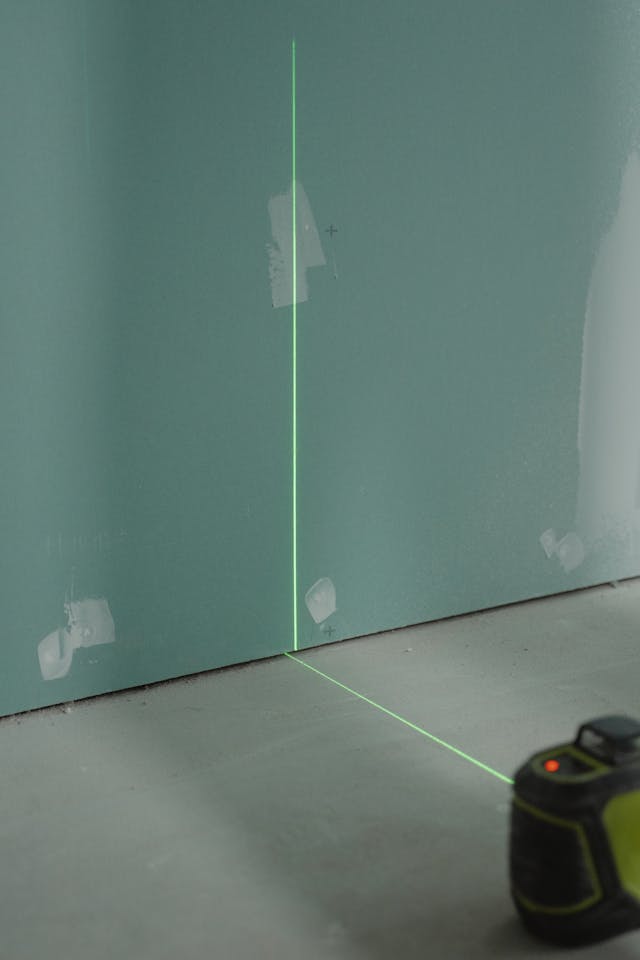 blue plasterboard with a green level shining across the middle of it