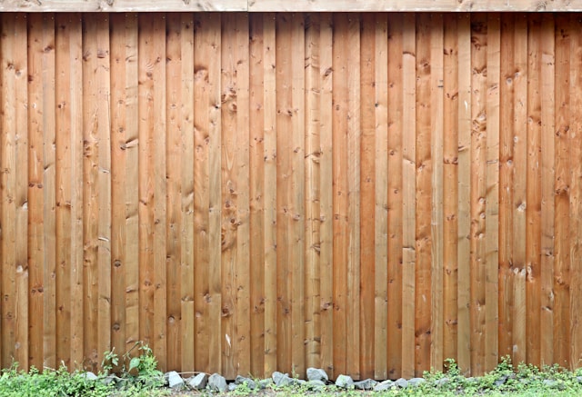a treated timber fence with grass at the bottom